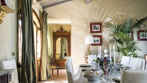 Un coin repas avec une table mise pour le repas, un grand miroir et une plante en pot.