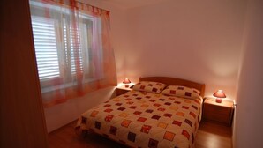 A bedroom with a bed, two bedside lamps, a window with blinds, and a curtain. - Apartment in Lumbarda with Seaview, Terrace, Air condition, WIFI (128-2) (Lumbarda)