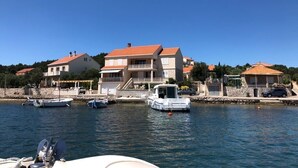 A waterfront property with multiple buildings, a dock with boats, and a clear blue sky. - Apartment in Lumbarda with Seaview, Terrace, Air condition, WIFI (128-2) (Lumbarda)