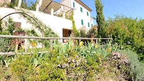 A white building with green shutters, a balcony, and a garden with various plants and flowers. - Country House / Farm House in Aiale with 3 bedrooms sleeps 8 (Aiale)