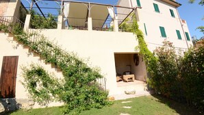 A two-story building with a covered outdoor seating area and a staircase leading to the upper floor. - Country House / Farm House in Aiale with 3 bedrooms sleeps 8 (Aiale)