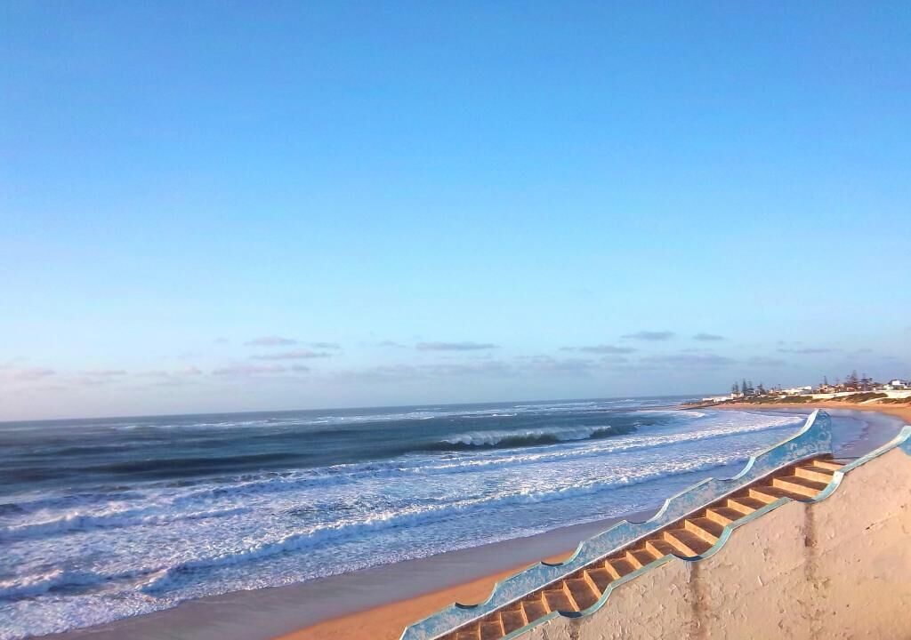 Ein Strand mit einer Betonstairtreppe, die zum Ufer führt.