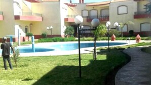 A courtyard with a swimming pool, a walking path, and buildings with balconies. - Nice apartment with pool access 4300 (Sidi Bouzid)