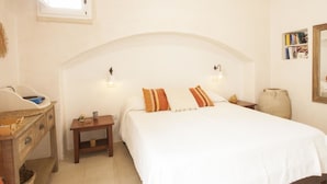 A bedroom with a large bed, two bedside lamps, a wooden nightstand, a small table with a vase and a book, and a window with a view of the sky. - Country Resort in Torre Suda with 1 bedrooms sleeps 2 (Torre Suda)