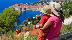 Une ville côtière qui se distingue par son imposant château, sa mer d’un bleu éclatant et la vue qu’elle offre sur les bâtiments de la ville, reconnaissables à leurs toits rouges.