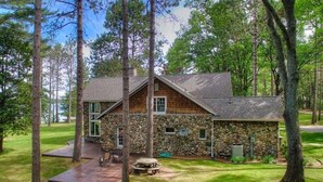 Un chalet rustique avec une façade en pierre, une terrasse en bois et une table de pique-nique.
