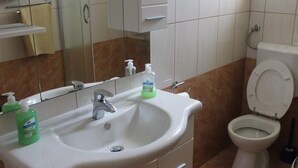A bathroom with a white sink, a mirror, a toilet, and a shelf with a towel. - Holiday Home in Preko with Seaview, Terrace, Air condition, WIFI (4571-1) (Preko)