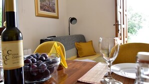 A dining area with a table set for two, a bottle of wine, a bowl of fruit, and a painting on the wall. - Apartment in Roč with Terrace, Air condition, WIFI, Washing machine (4194-2) (Roc)
