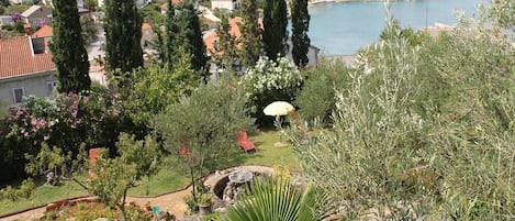 Un quartier résidentiel situé sur la côte, avec des maisons, un jardin et une vue sur la mer.