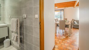 Un baño con baldosas grises, un lavabo blanco y un perchero para toallas.