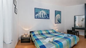 Una camera d'albergo con un letto, comodini, uno specchio e opere d'arte alle pareti.