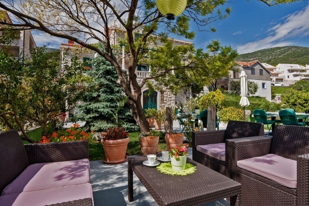 An outdoor seating area with wicker furniture and potted plants.