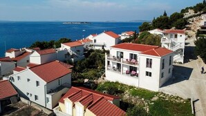 A coastal residential area with white buildings and red-tiled roofs. - Apartment in Tribunj with Seaview, Terrace, Air condition, WIFI (4265-1) (Tribunj)
