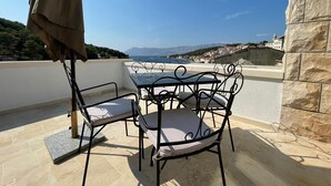 A terrace with a table and chairs, overlooking a coastal view. - Apartment in Povlja with Seaview, Terrace, Air condition, WIFI (3419-2) (Povlja)