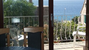 Ein Balkon mit Meerblick, einem Stuhl und einem Tisch.