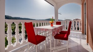 A balcony with a table and chairs, a vase with flowers, and a view of the countryside. - Apartment in Lopar with Terrace, Air condition, WIFI, Washing machine (4360-2) (Lopar)