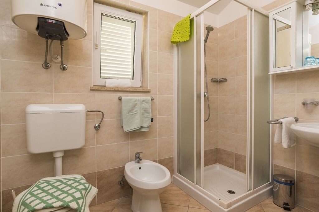 Ein Badezimmer mit Toilette, Bidet, Dusche und Waschbecken.