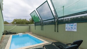 A swimming pool with a glass enclosure, a hose, and a sign indicating pool rules. - Apartment in Umag with Balcony, Air condition, WIFI (653-2) (Umag)