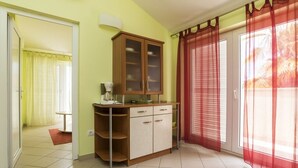 A room with a wooden cabinet, a small table, and a red curtain. - Apartment in Umag with Balcony, Air condition, WIFI (653-2) (Umag)