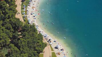 Ranta lähistöllä, aurinkovarjoja