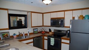 A compact kitchen with a microwave, stove, refrigerator, and a sink. - On the Promenade 1st floor. Spectacular Panoramic Ocean Views, Patio with grassy (Seaside)