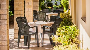 An outdoor patio area with a table and chairs, surrounded by arches and potted plants. - Holiday Home in Lopar with Seaview, Terrace, Air condition, WIFI (186-5) (Lopar)