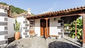 A courtyard with a stone floor, a wooden bench, a cactus, and a pergola. - Villa de Mazo, La Palma (Villa de Mazo)