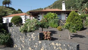 A white building with a red-tiled roof, surrounded by a stone wall and various plants. - Villa de Mazo, La Palma (Villa de Mazo)