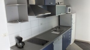 A modern kitchen with grey and blue cabinets, a stainless steel range hood, a microwave, and a coffee maker. - Apartment in Umag with Seaview, Balcony, Air condition, WIFI (235-1) (Umag)