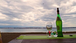 A bottle of wine and a glass on a table with a view of the sea and a cloudy sky. - Apartment in Poljana with Seaview, Terrace, Air condition, WIFI (3617-4) (Poljana)