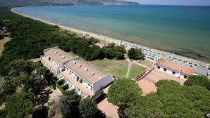 Ein Küstenhotel mit langem Gebäude, Strand und freiem Blick auf das Meer.