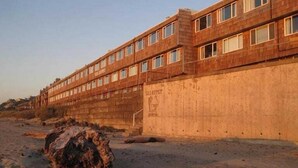 Un edificio alto de varios pisos con fachada de ladrillo y numerosas ventanas.