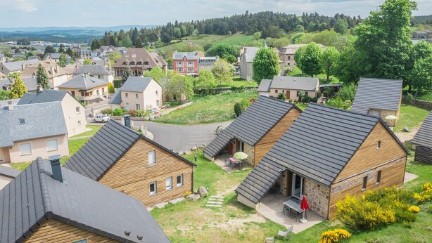 A residential area with houses featuring sloped roofs and wooden exteriors.