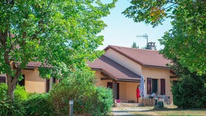 Ein Haus mit Ziegeldach, einer Veranda und einem Kiesweg, der zum Eingang führt.
