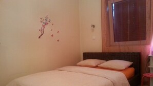A bedroom with a bed, a wall decoration of a tree and butterflies, a window with wooden shutters, and a small stool. - Apartment in Zagreb with Balcony, WIFI, Washing machine (4292-1) (Zagreb)