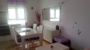 A modern living room with a dining area, a kitchen, and a large window. - Apartment in Zagreb with Balcony, WIFI, Washing machine (4292-1) (Zagreb)