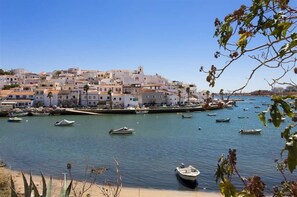 A coastal town with buildings along the waterfront, boats in the water, and a clear sky.