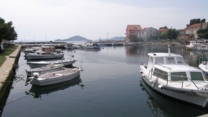 A marina with several boats docked along a calm waterway, surrounded by buildings and greenery. - Apartment in Poljana with Seaview, Terrace, Air condition, WIFI (4232-1) (Poljana)