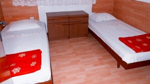 A small, clean room with two single beds, a wooden nightstand, and a window with lace curtains. - Apartment in Poljana with Seaview, Terrace, Air condition, WIFI (4232-1) (Poljana)