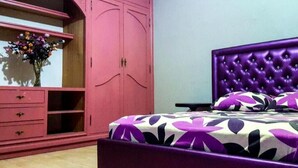 A bedroom with a purple bed, a pink wardrobe, and a floral bedspread. - Level of villa in Marrakech 3557 (Marrakech)