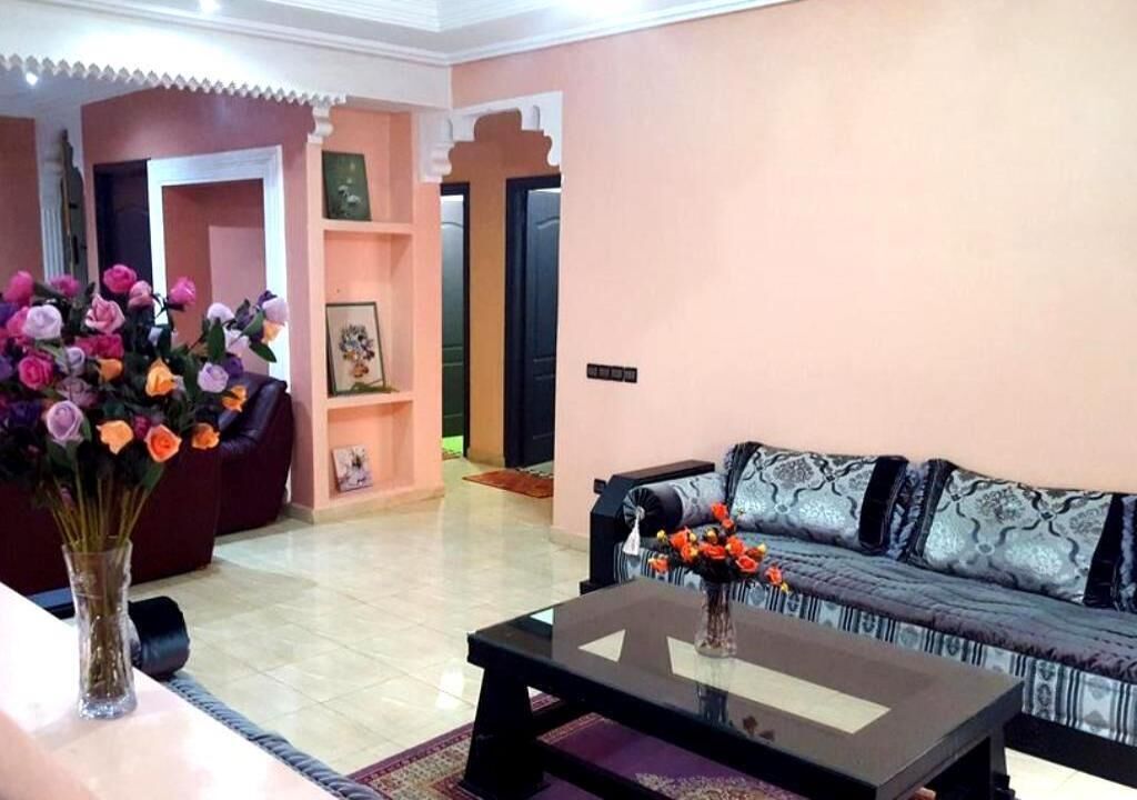 Een woonkamer met een bank, een salontafel en een bloevas.