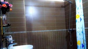 A bathroom with a white sink, a shower with a blue shower curtain, and tiled walls. - Level of villa in Marrakech 3557 (Marrakech)