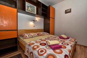 A bedroom with a bed, a nightstand, a dresser, and a wall-mounted shelf with a picture. - Apartment in Pisak with Seaview, Terrace, Air condition, WIFI (77-2) (Pisak)