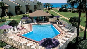 A swimming pool surrounded by lounge chairs and umbrellas, with a view of the ocean and palm trees. - 2 Bedroom Townhome with a Gulf View and King Beds (Miramar Beach)