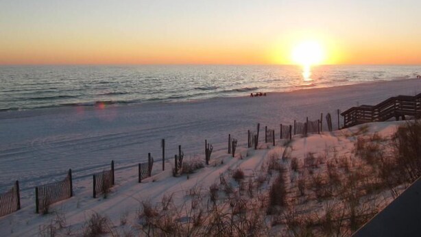 A beach with a wooden fence and a sunset. - 2 Bedroom Townhome with a Gulf View and King Beds (Miramar Beach)
