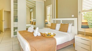 Una habitación de hotel con cama, mesita de noche, armario y ventana con persianas.