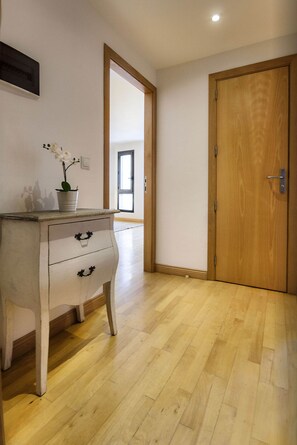 A hallway with a wooden floor, a white dresser with two drawers, and a wooden door. - El Estudio de Lela, Your very home in the heart of Arrecife (Arrecife)
