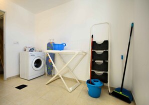 A laundry area with a washing machine, ironing board, and mop. - El Estudio de Lela, Your very home in the heart of Arrecife (Arrecife)