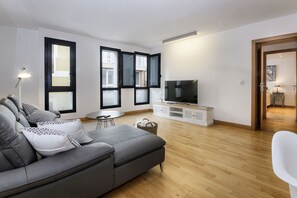 A modern living room with a grey sofa, a flat-screen TV, and a wooden floor. - El Estudio de Lela, Your very home in the heart of Arrecife (Arrecife)
