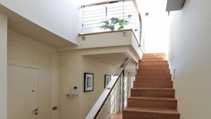 A staircase with a wooden finish, white walls, and a small balcony with a plant. - Club Villamar - Fully detaches 8-persons vila, ideal for families at only 4 kilometers away from ... (Mont Ras)